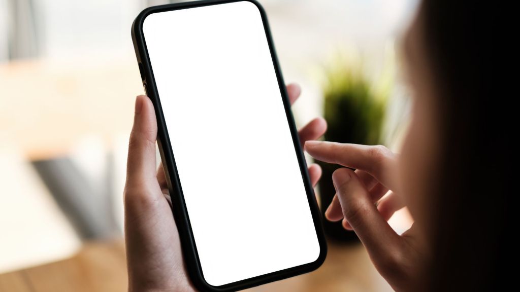 A person holding a blank smartphone about to press on the screen with their finger while holding it with their other hand.  They are getting started on their storytelling journey.
