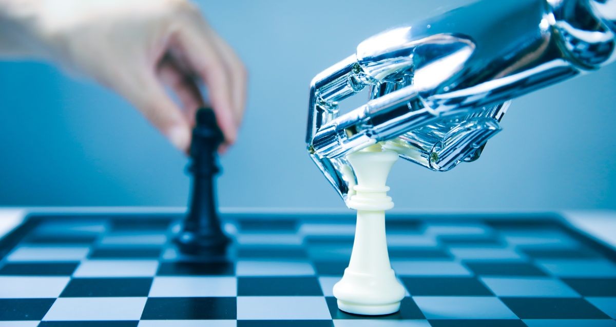 A robotic hand holds a white chess piece on a chessboard, while a human hand moves a black chess piece in the background, illustrating a human vs. AI scenario.
